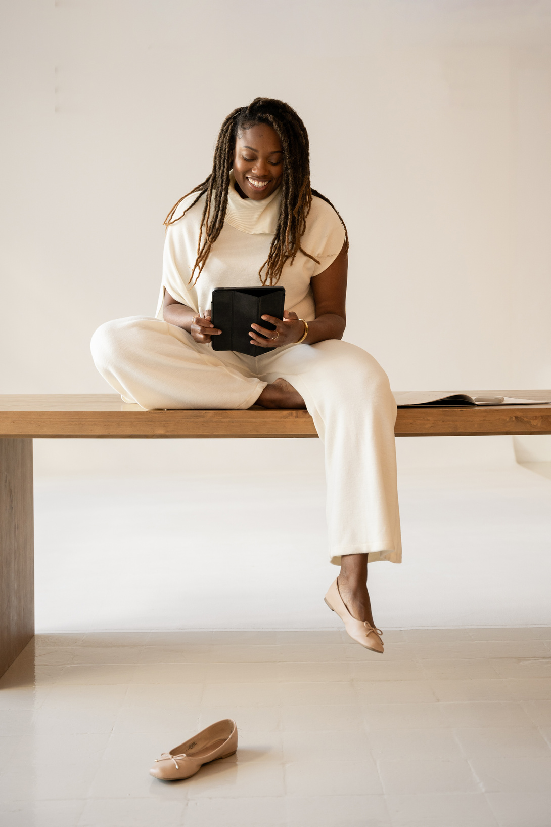 Elegant Office Business Woman Sitting on a Table with Tablet